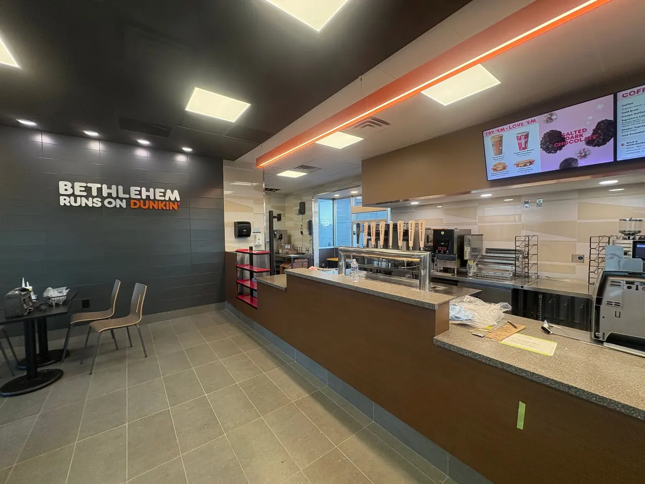 Newly built Dunkin counter with menu boards and overhead lighting