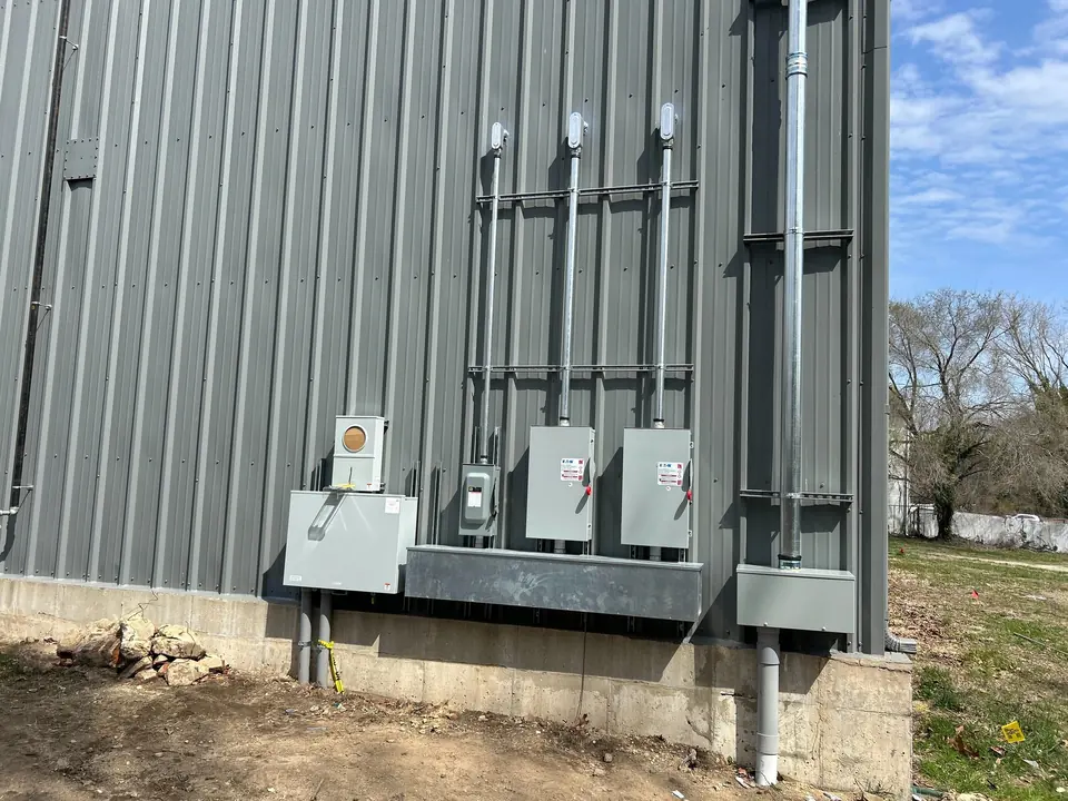 Meter bank and disconnects on the side of a metal building