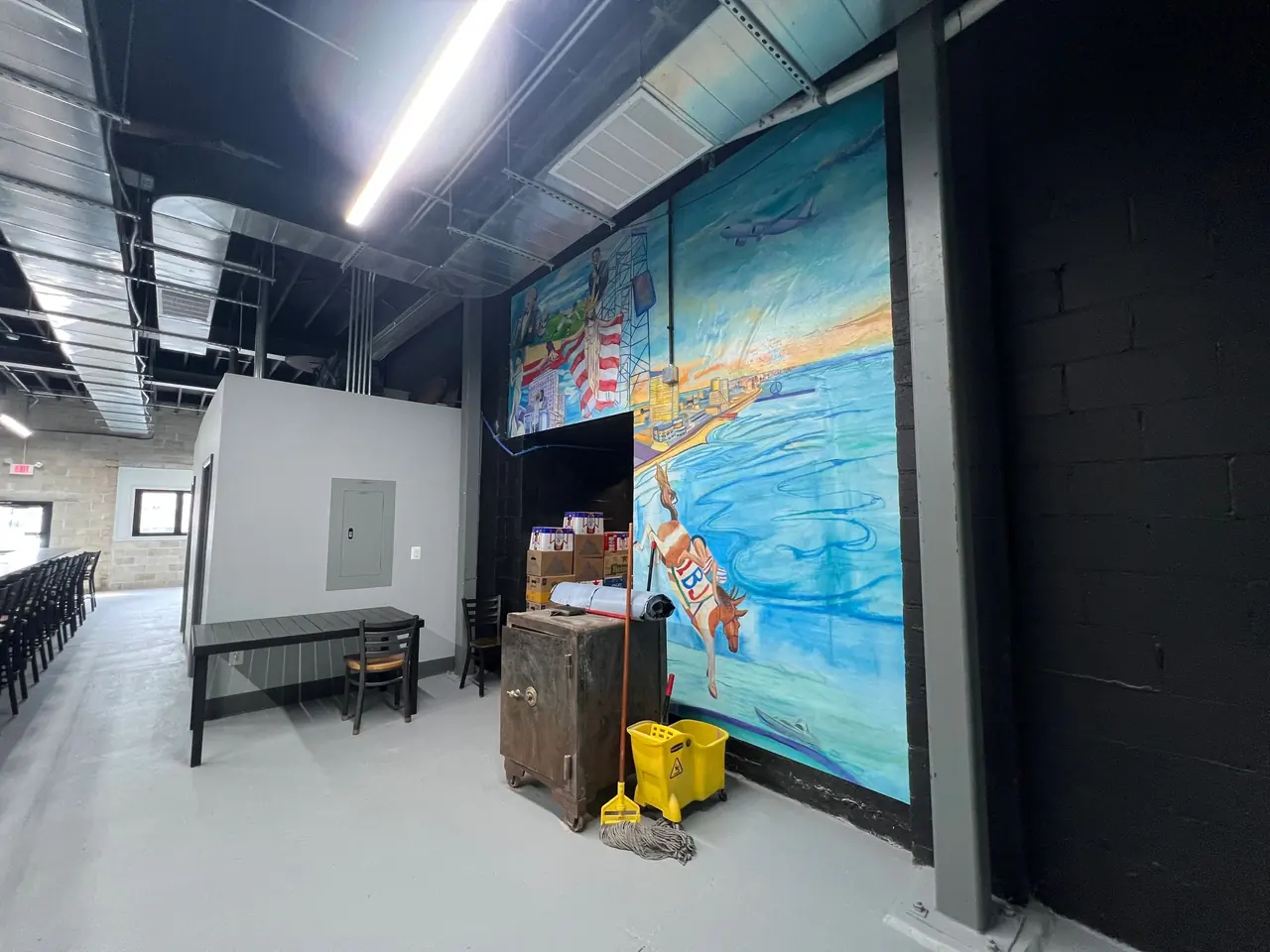Restaurant interior with a large hand-painted mural and new lighting