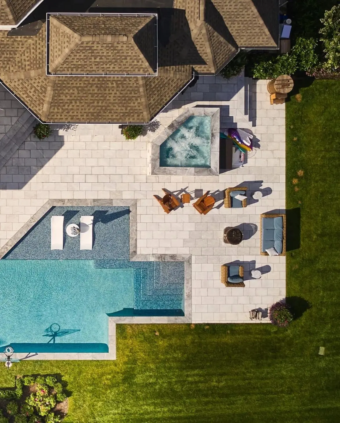 Aerial view of a pool, spa and patio behind a home