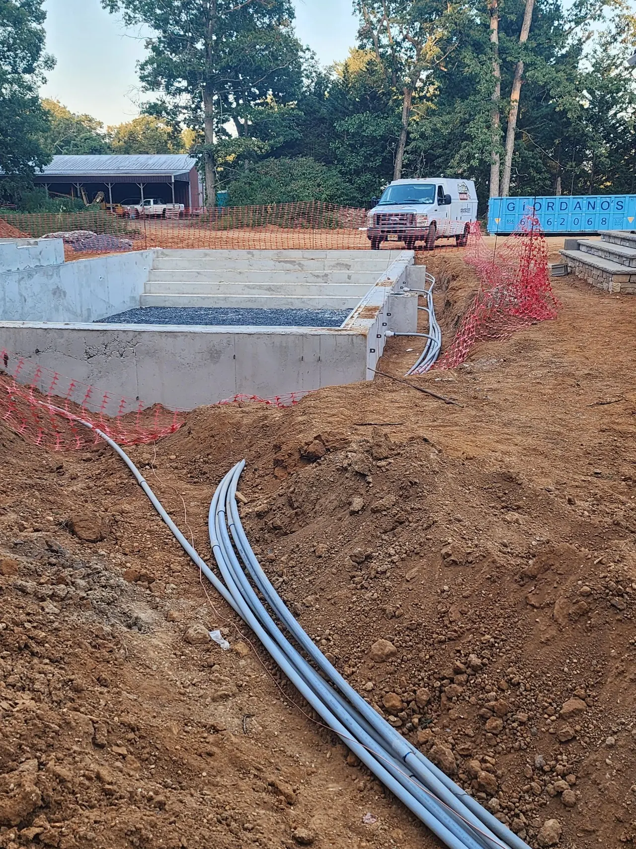 Conduit run in a trench beside a new pool excavation