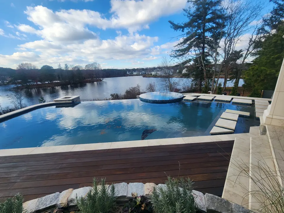 An infinity pool and spa overlooking a lake